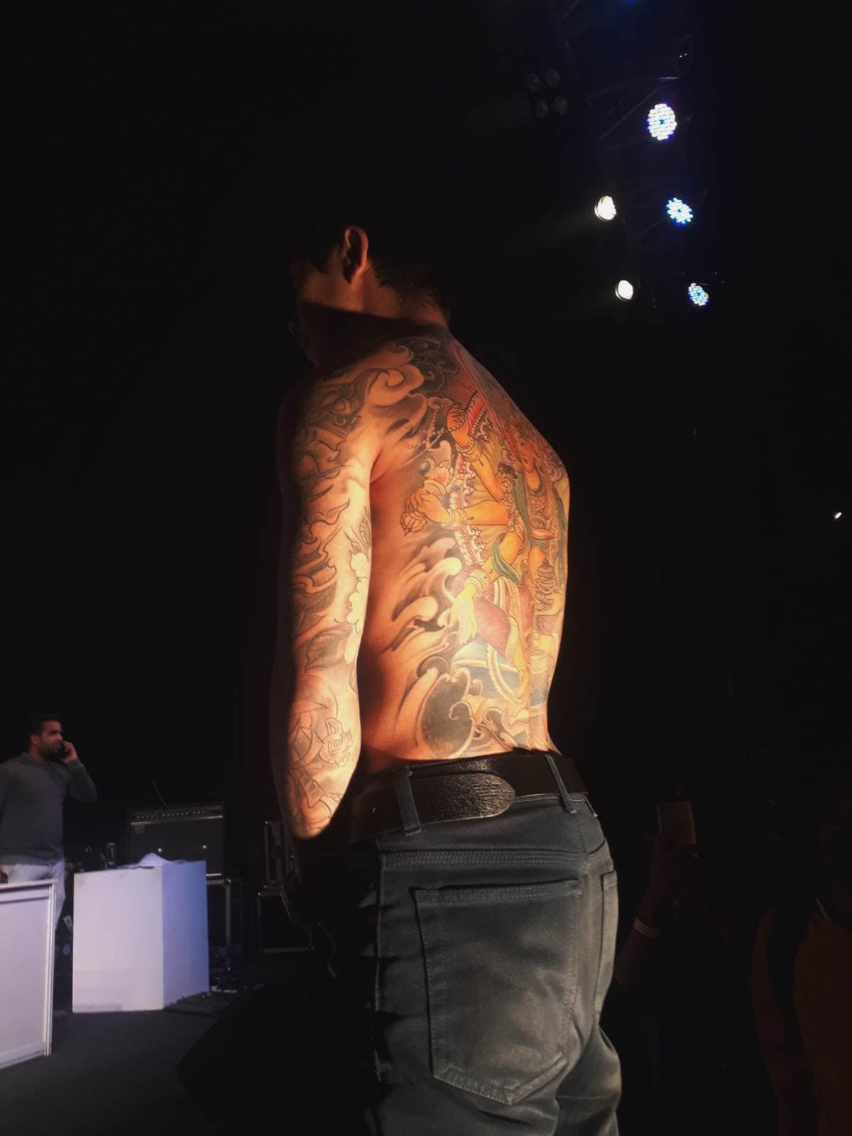Full back and sleeve tattoo displayed on stage