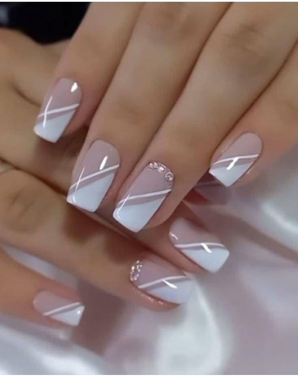 White and nude nails with diagonal stripes and crystals