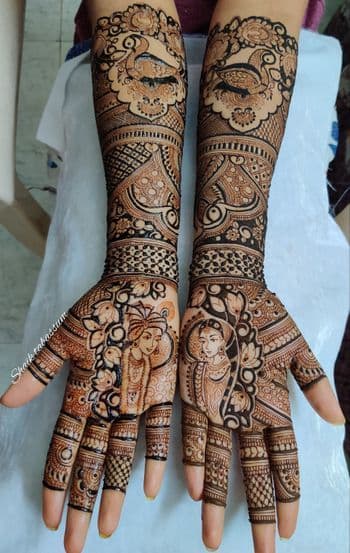 Full-arm bridal mehandi featuring bride portrait on palm